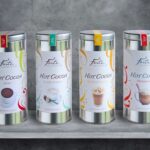 4 tins of Forte hot cocoa lined up on a shelf with a grey background