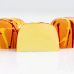 3 passion fruit truffles in bright orange with red and yellow splatters