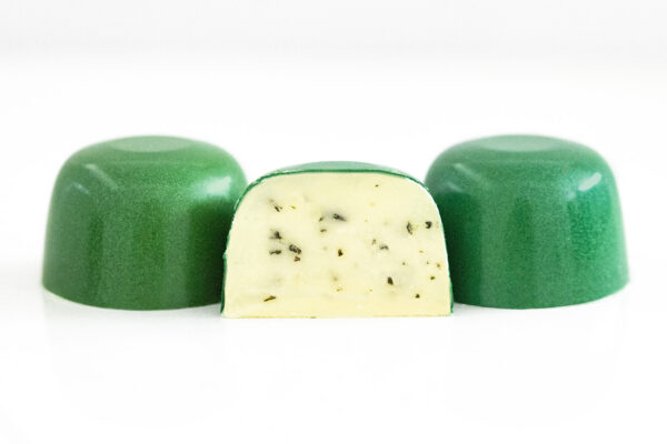 Picture of beautiful white chocolate and butter ganache mixed with fresh chopped rosemary herbs with coarse sea salt inside emerald green colored crisp chocolate shells