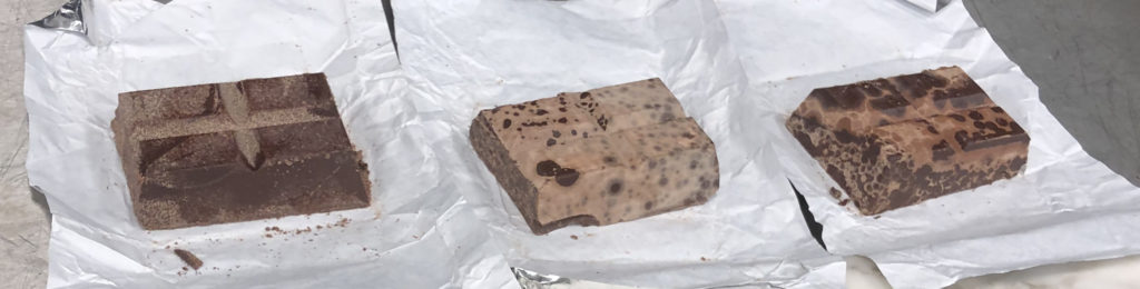 3 blocks of chocolate showing fat bloom and sugar bloom, does chocolate go bad, how to tell if chocolate is bad, how long does chocolate last, chocolate shelf life, signs chocolate is expired, chocolate storage tips, tempering chocolate, how to temper chocolate