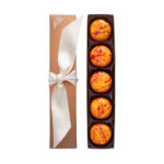 5 piece passion fruit truffle box open with white ribbon on top and brilliant orange truffles with red and yellow splatters