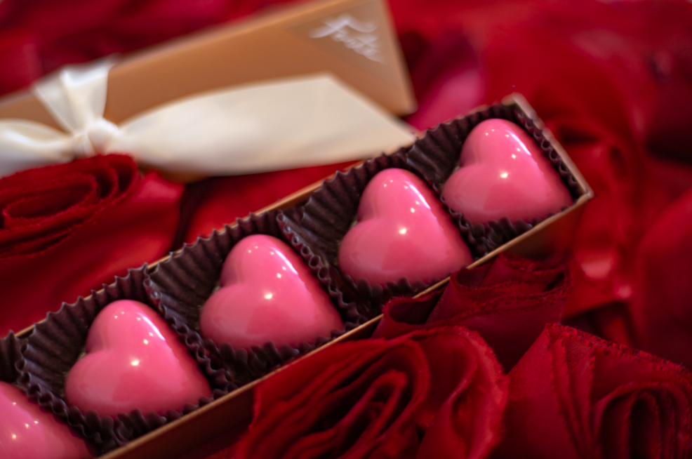 Closeup of a 5 piece pink chocolate truffle box on elegant red velvet