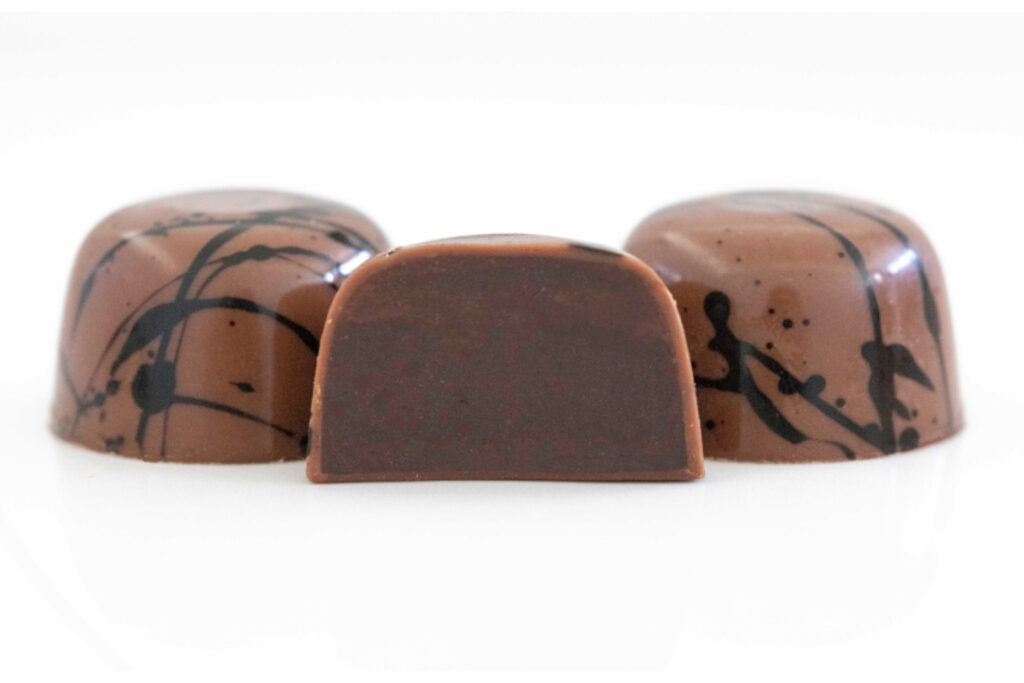 3 Espresso Truffles with center truffle cut. This award-winning, reimagined classic truffle features superb local espresso beans from Olympia Coffee steeped in cream for our luscious ganache.