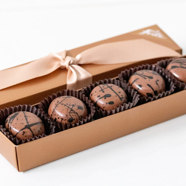 5 piece box of gourmet Espresso Truffles on marble coasters. This award-winning, reimagined classic truffle features superb local espresso beans from Olympia Coffee steeped in cream for our luscious ganache.