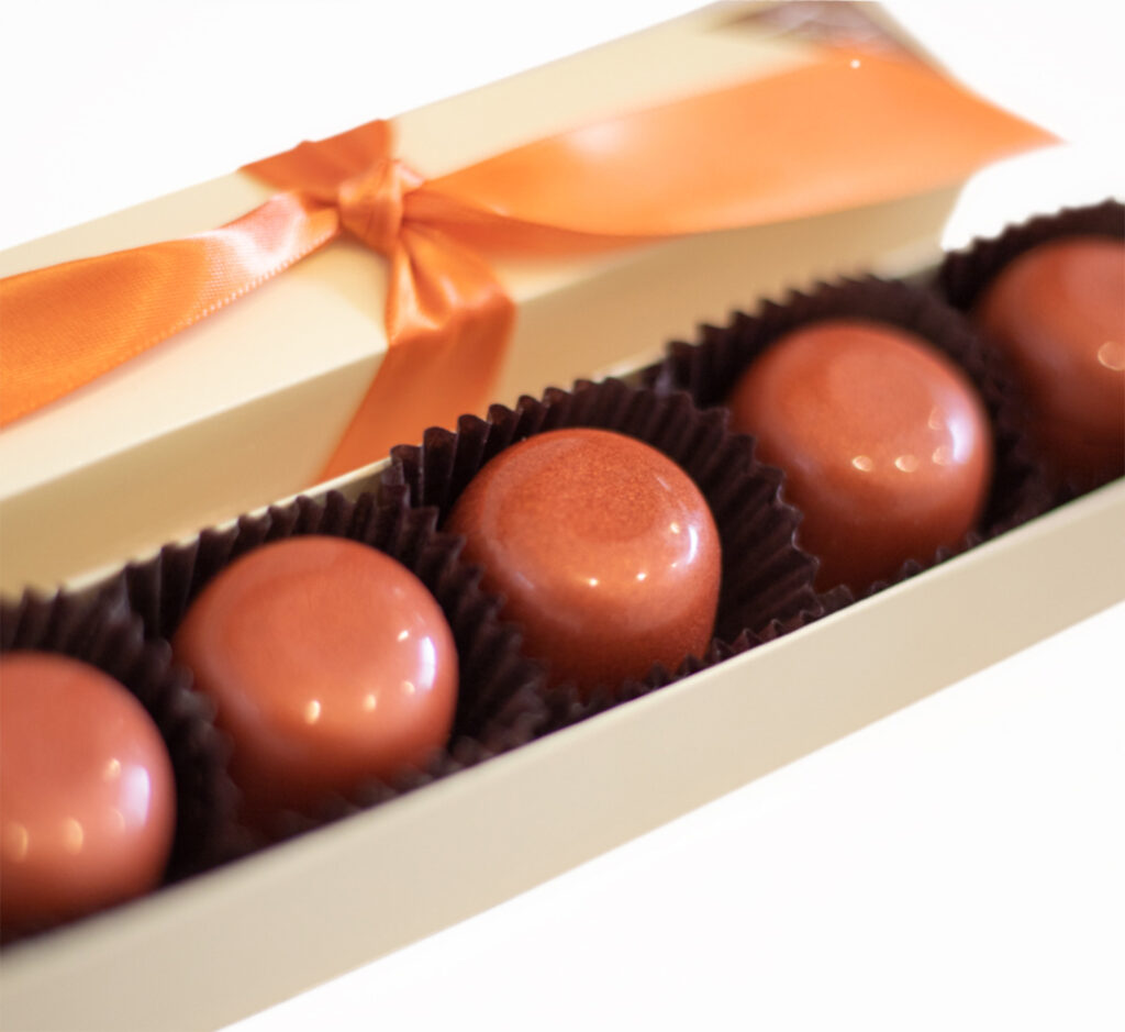5 piece box of classic milk chocolate truffles in brown cups with orange ribbon
