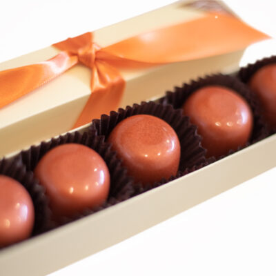 5 piece box of classic milk chocolate truffles in brown cups with orange ribbon