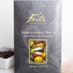 Fortunato number 4 packaging next to a ramekin of cacao nibs and light dusting of cocoa powder