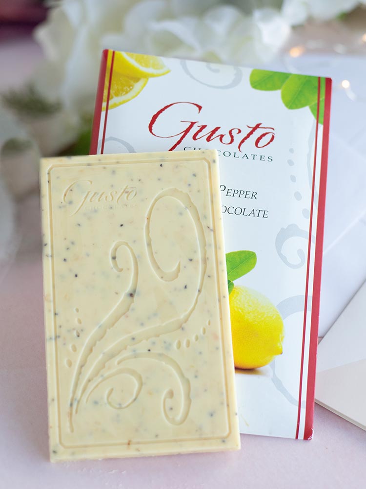 Gusto lemon pepper in white chocolate bar on top of packaging sitting on white table