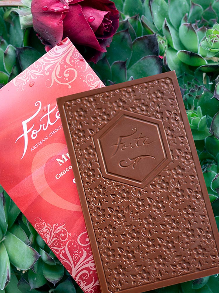 Unwrapped Forte Milk Love chocolate bar showing Forte logo and bar mold design atop the red packaging