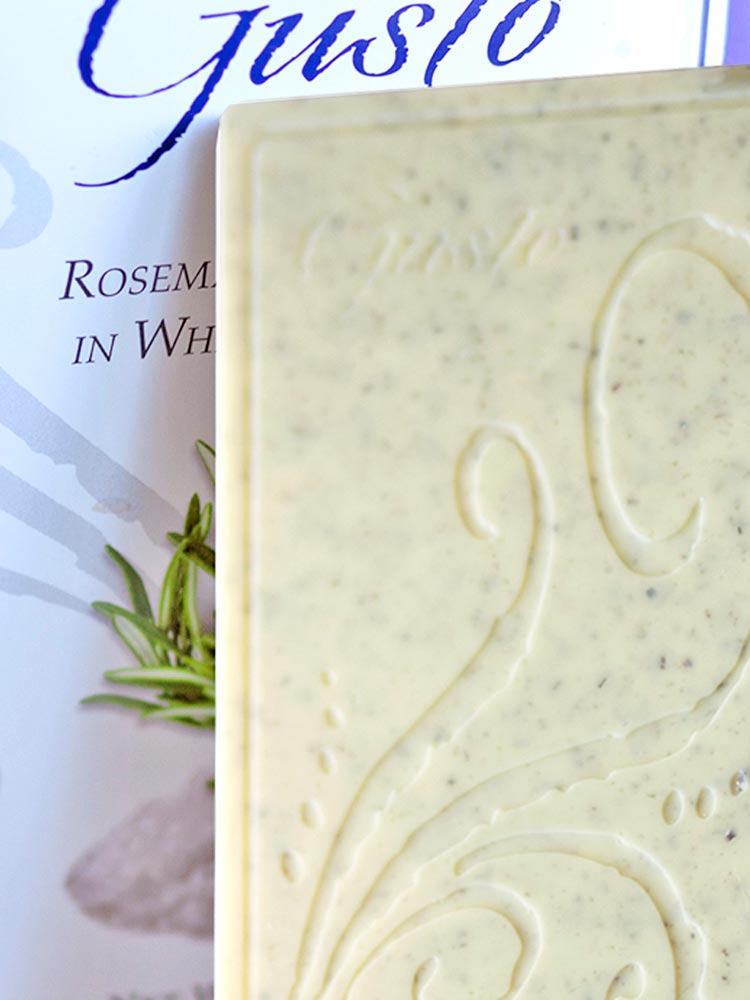 Close up of rosemary sea salt in white chocolate bar and packaging