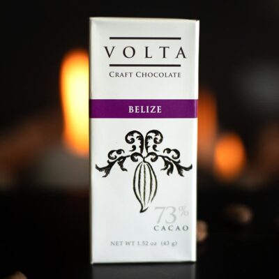 Volta Belize bar wrapper with cacao beans in foreground and candlelight in back