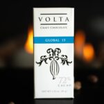 Volta Global 15 packaging on a table with scatter cacao beans and candlelight