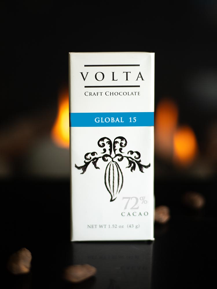 Volta Global 15 packaging on a table with scatter cacao beans and candlelight