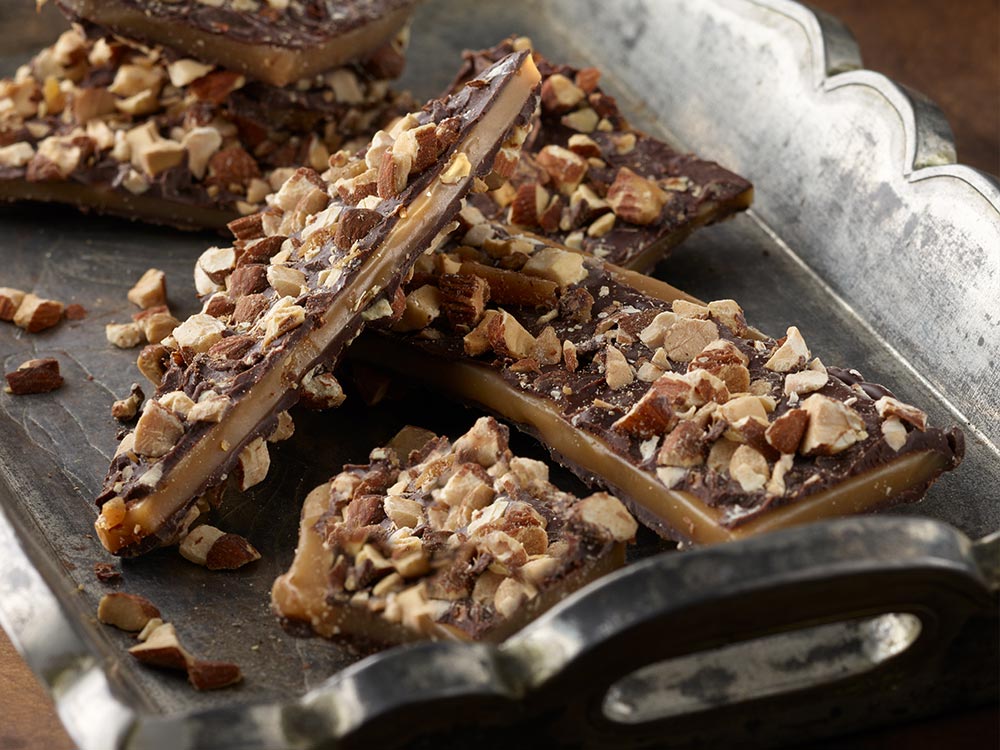 Close-up of almond toffee butter crunch arranged on an antique silver tray