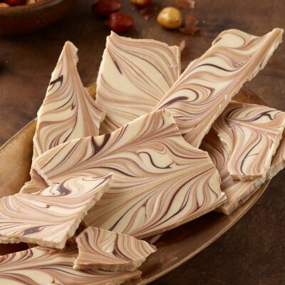 Tiger stripes bark arranged on a gold platter with a bowl of peanuts in the background