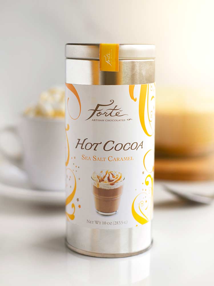 Tin of Forte sea salt caramel hot cocoa with filled mug in background