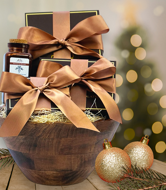 Wooden bowl filled with luxury chocolate gift boxes tied with double faced satin ribbon