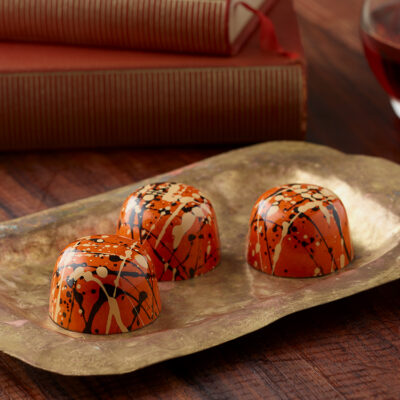 3 Pumpkin Spice truffles on a gold serving plate with books in background