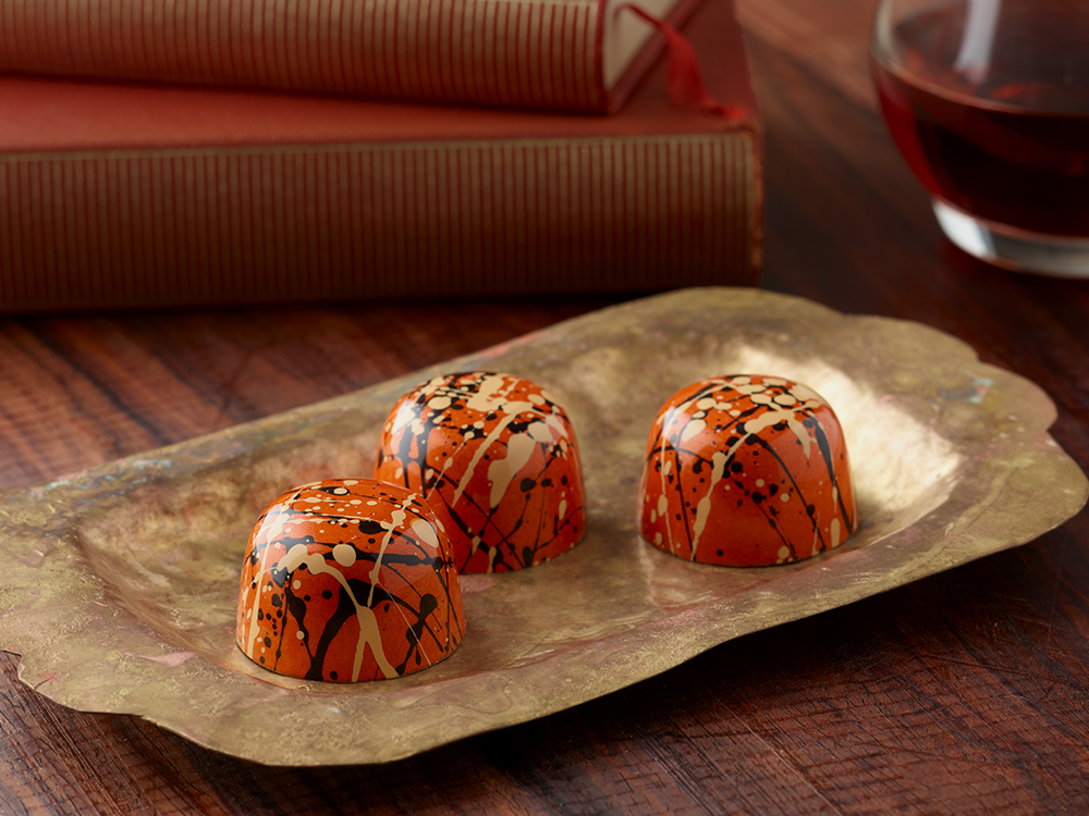 3 Pumpkin Spice truffles on a gold serving plate with books in background